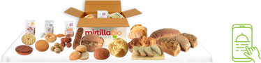 Un assortimento di prodotti da panetteria e pasticceria intorno a una scatola di cartone aperta, indicando una selezione di articoli non deperibili adatti per la spedizione Express